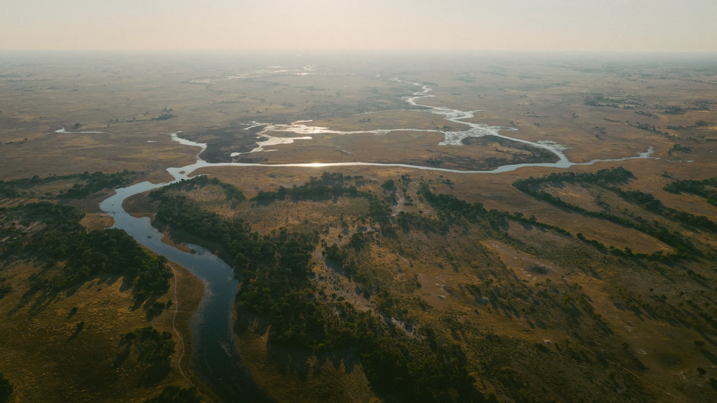 A river winding across the Delta in low light, seen from the air