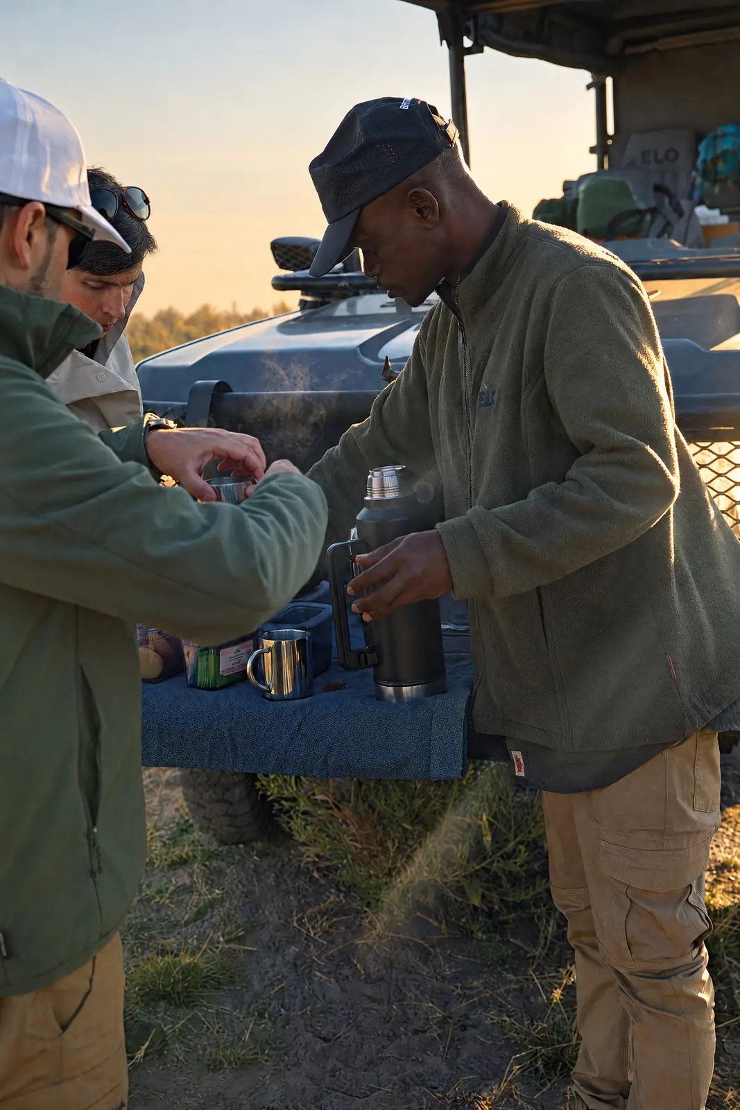 A guide pouring coffee on the morning game drive