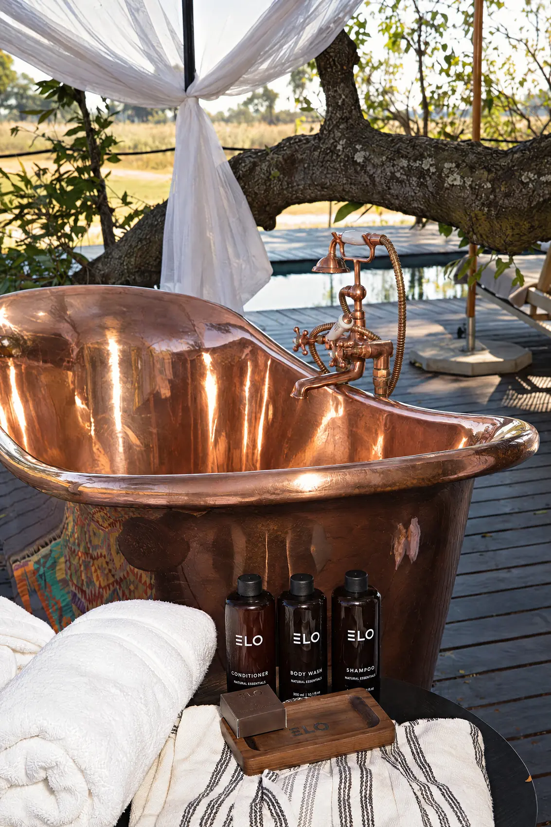 The copper bath on the villa deck, under the trees