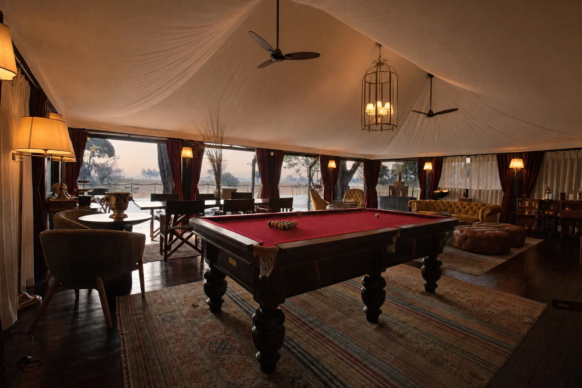 A billiard table under the canvas of the lounge house, the floodplain beyond the windows