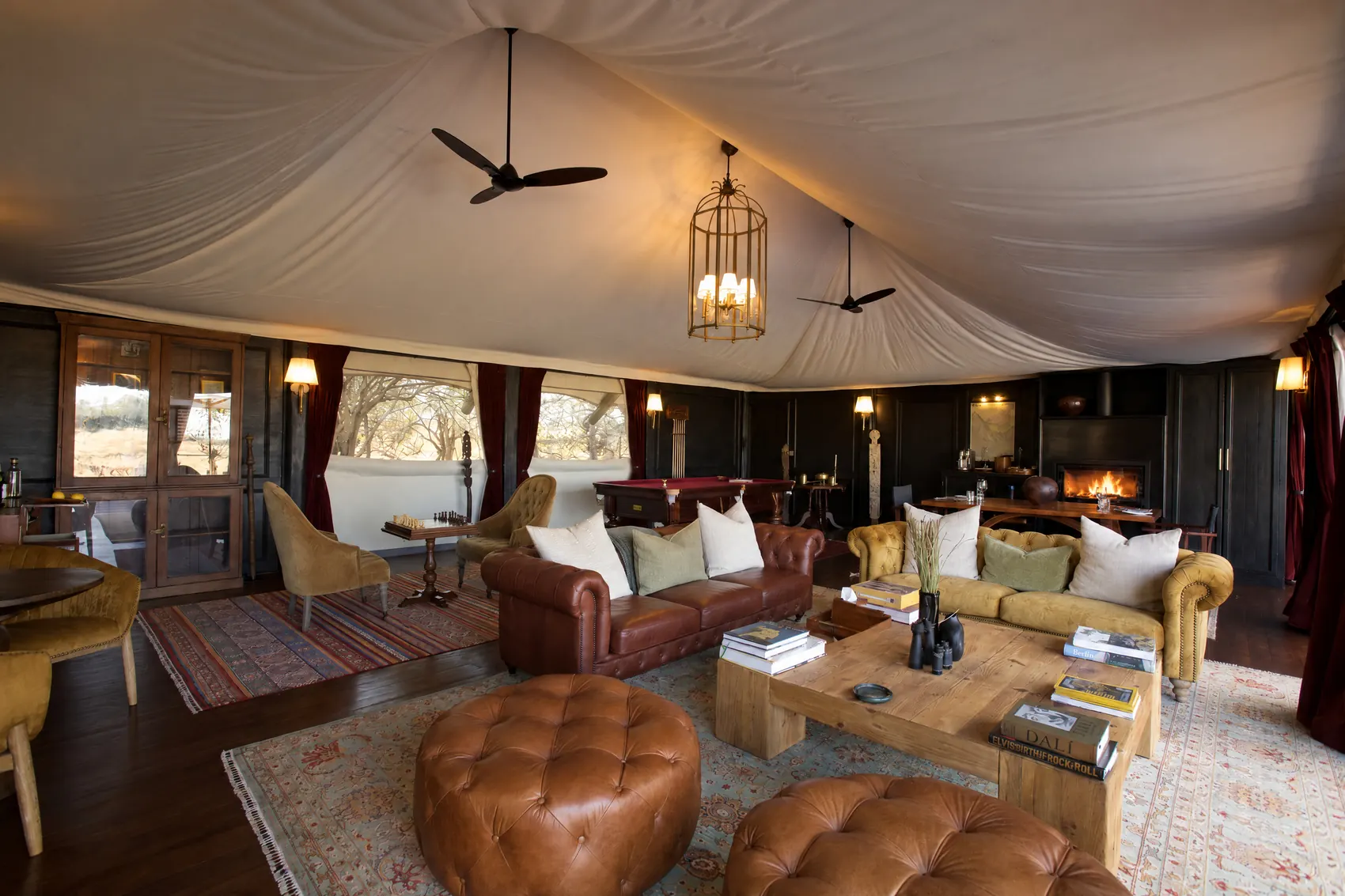 Leather sofas and ottomans in the lounge house, the fire lit