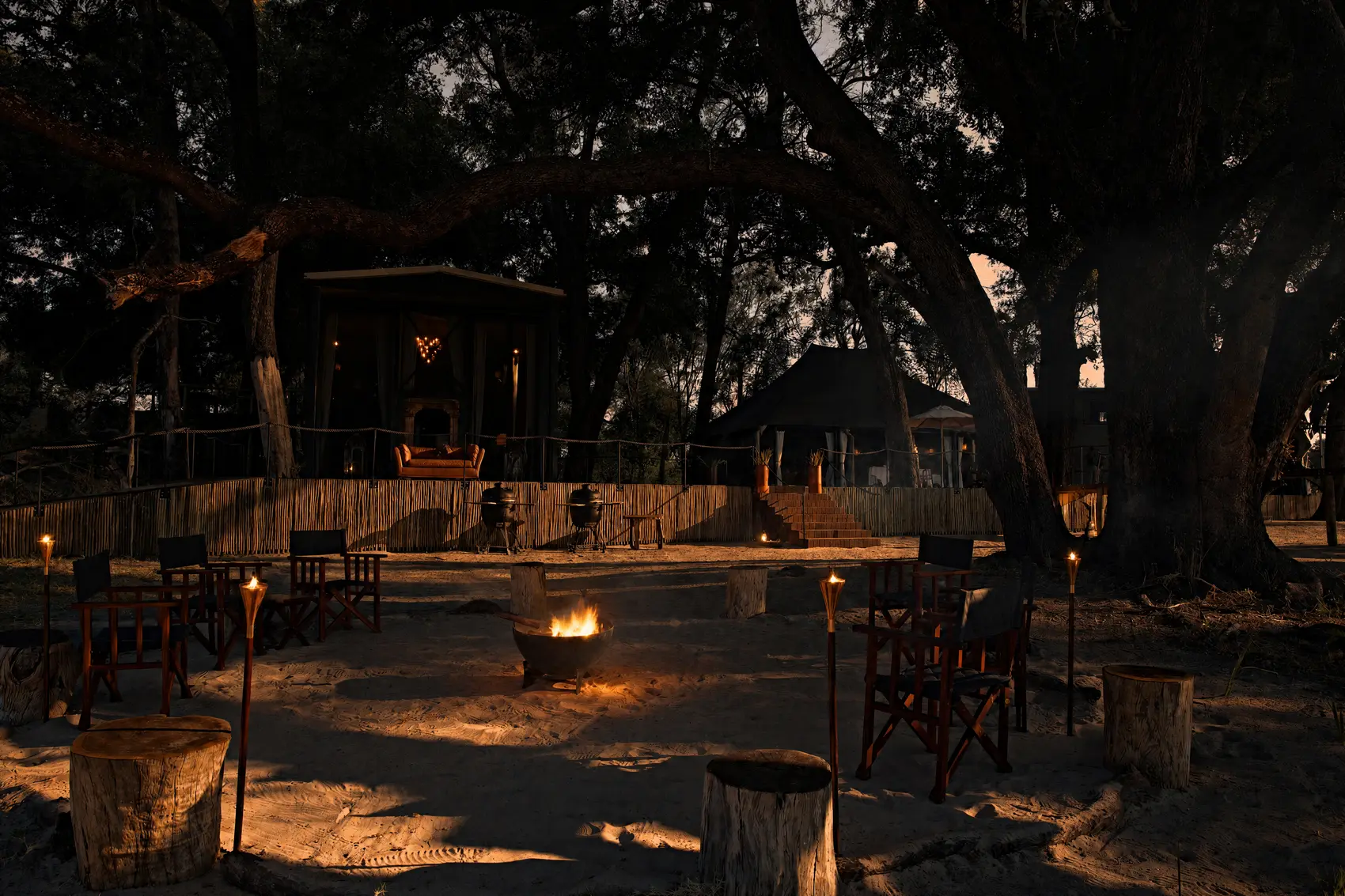 A fire burning in its circle under the trees at dusk